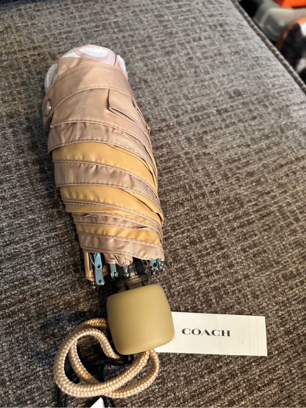 Coach Compact Folding Umbrella in Beige and Yellow with matching cover.